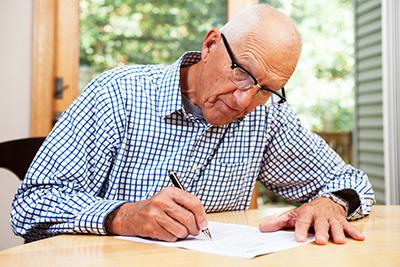Old man writing on a paper